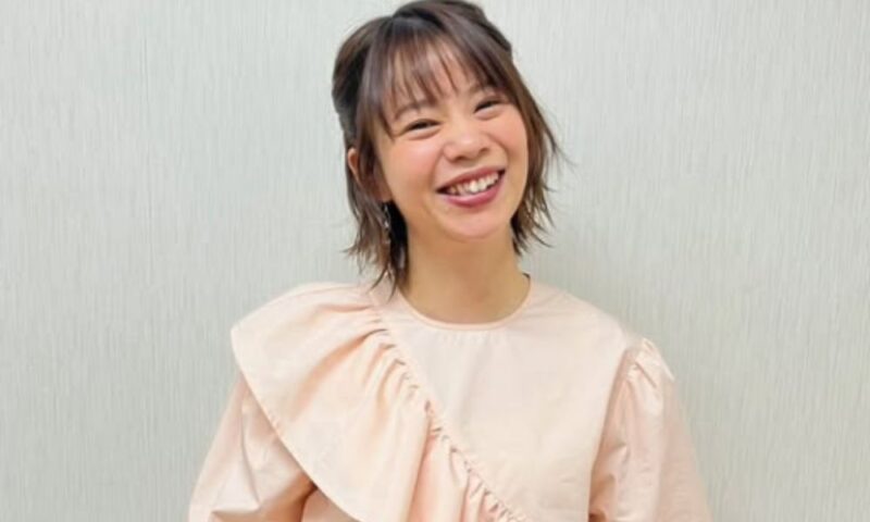 淡いピンクの衣装を着た髙木菜那さんが笑顔でポーズをとるスタジオ風ショット、テレビ出演時のコーデ紹介より