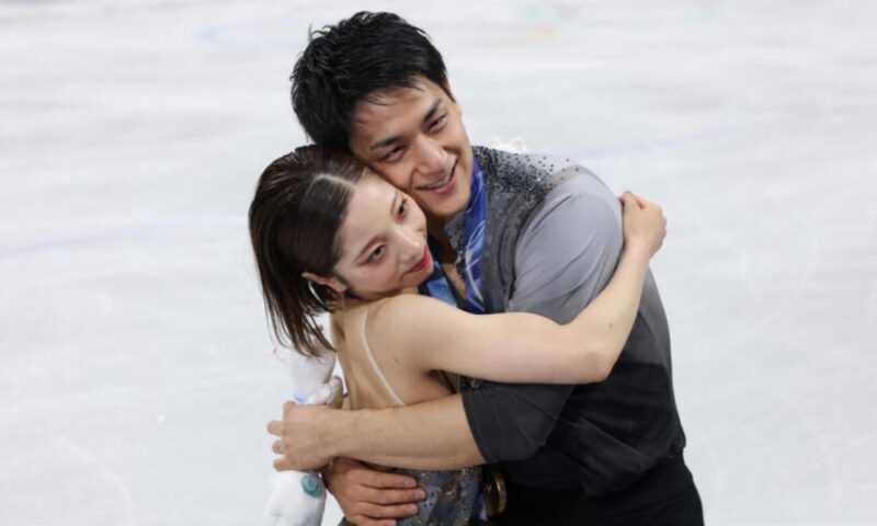 氷上で抱き合い喜びを分かち合うりくりゅうペア