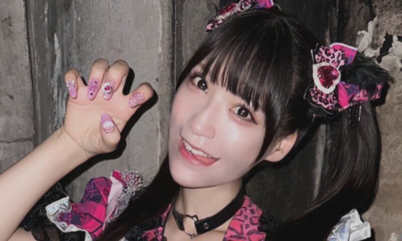 ライブ衣装を着用し、カメラに向かってポーズを取る愛成来来のアップ写真