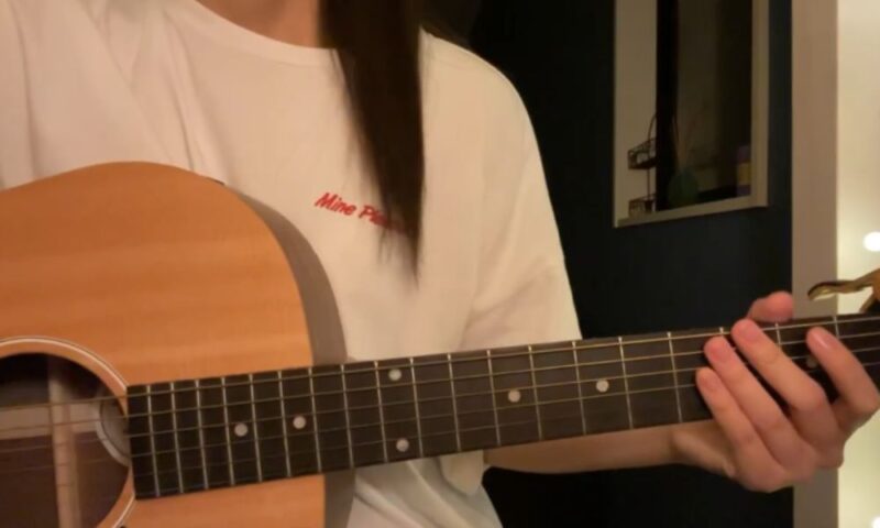 tuki.がアコースティックギターを弾く様子(顔は映っていない)