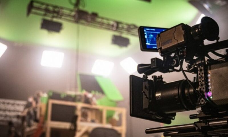 テレビスタジオで撮影機材と照明が並ぶ制作現場の様子