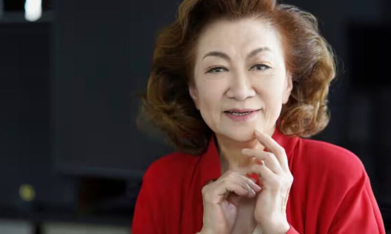 赤い衣装を身にまとい、落ち着いた表情で微笑む大月みやこのポートレート。上品で穏やかな雰囲気が印象的な一枚。