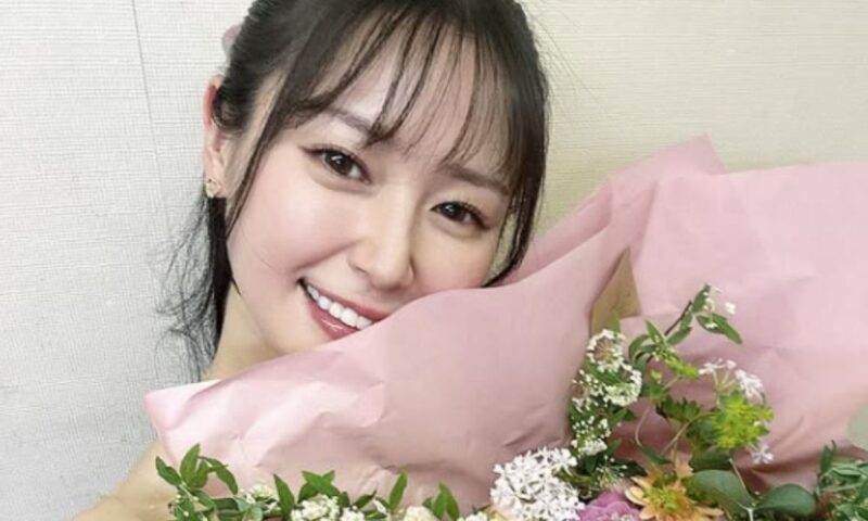 西口プロレスのリングガールとして活動してきた荒井つかさが、西口向上委員会の卒業を報告し花束を持って笑顔を見せる様子