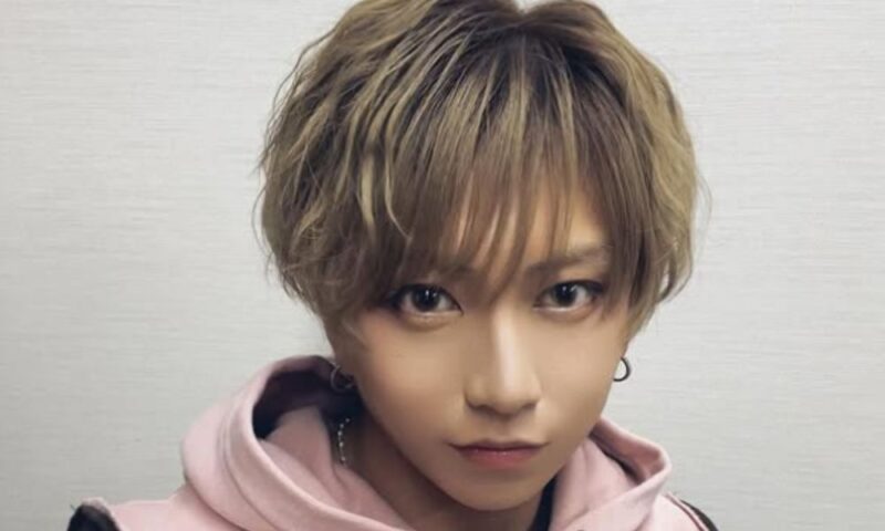 高橋祐理のバストアップ写真、明るいブラウンのショートヘアでピンクのパーカーを着用し、正面を見つめる表情