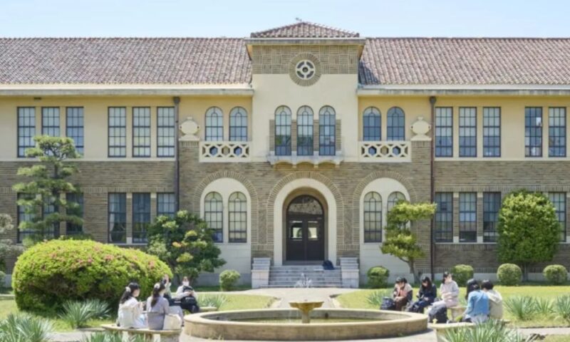 神戸女学院大学のキャンパス。レトロな建築物の前で、学生がくつろいでいる。