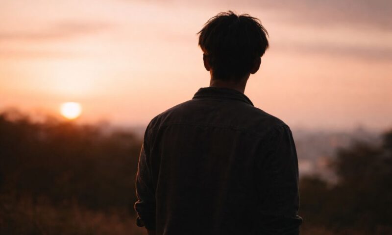 黒沢ともよの旦那をイメージした男性シルエット|夕暮れを背景にした後ろ姿のイメージ写真