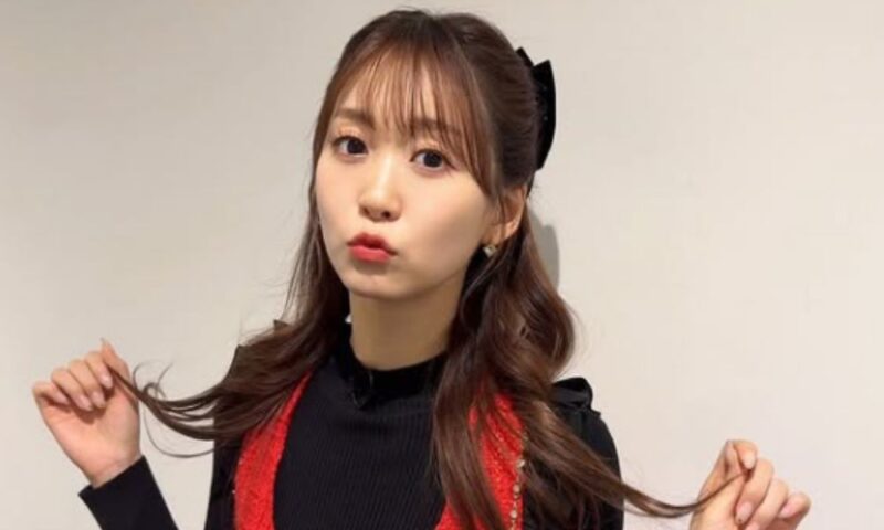 芹澤優のポートレート|黒リボンのヘアスタイルで髪を持ちながらポーズをとる可愛らしい表情の写真