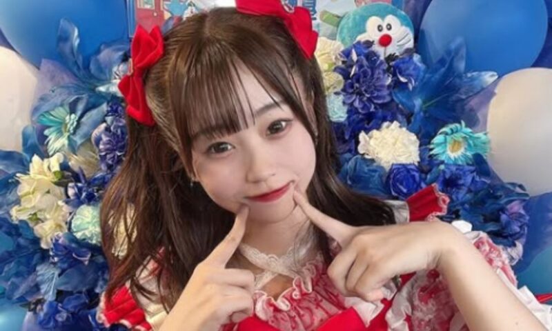 生誕祭のお祝いのスタンド花を背景にポーズをとる星野ほなみ(Re:♡)
