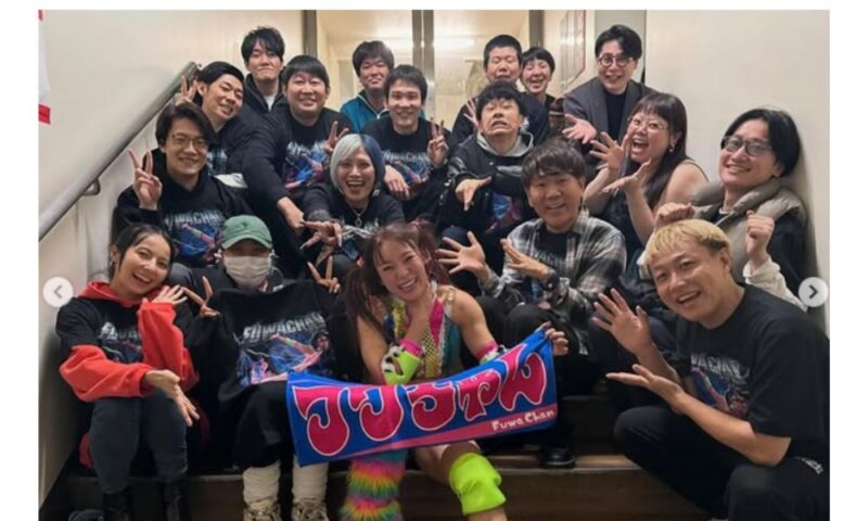 両国国技館でプロレス再デビュー戦を終えたフワちゃん。カラフルなリングコスチューム姿で名前入りタオルを持ち、応援に来た芸能人仲間と階段で笑顔の集合写真