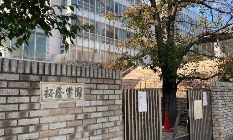 桜蔭学園の正門前のレンガ塀と校舎